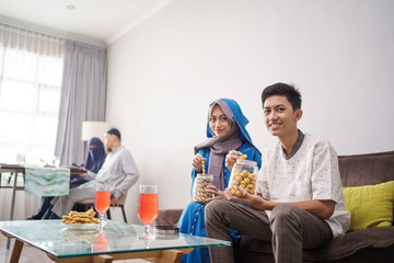 muslim teenage boy and girl smiling to camera while holding cake. eid mubarak festival