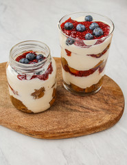 Healthy cheesecake in a mason jar and on top of a wooden board. Food styling & food photography for the culinary blog.