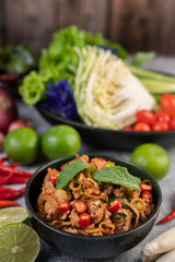 Spicy pork chops in a black cup consisting of lemons Chili and side dishes
