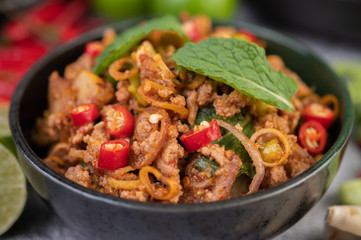 Spicy pork chops in a black cup consisting of lemons Chili and side dishes
