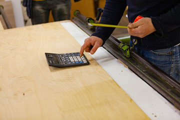 a worker holds a roulette wheel in his hands. Wood cutting on a machine. Wood Works. Circular Saw Machine At Work. Construction Tools.