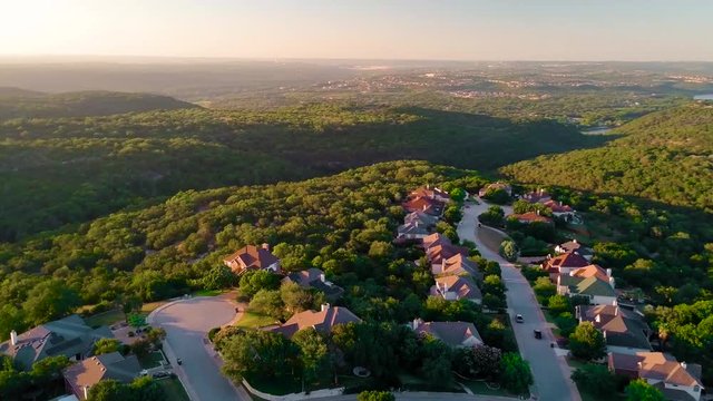 Golden hour sunset drone flight over suburban Texas Hill Country neighborhood