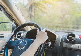 Hands female driving in her car.