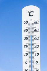 weißes Thermometer zeigt Hitzewelle an vor blauem Himmel Temperatur steigt über 30 Grad Celsius
