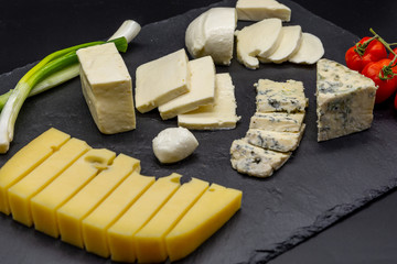 various assorted cheese on black slate