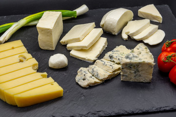 various assorted cheese on black slate