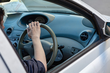 Naklejka premium Hands wipes the steering wheel with an antibacterial cloth. Infection control concept. Prevent Coronavirus, COVID-19, flu.