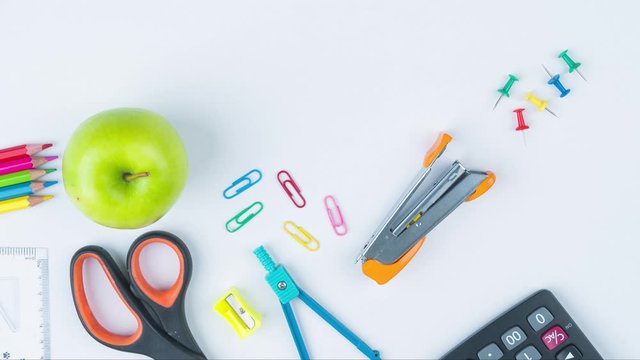Timelapse of apple with school supplies on table