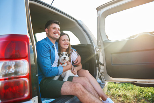 Happiness loving couple with dog enjoying the view in summertime.