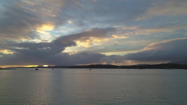 Dramatic sunset over large expanse of water with fast panning movement 