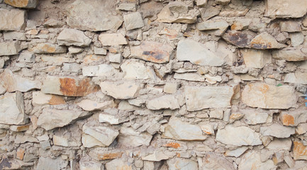 Texture of an old stone wall closeup as background. Antique flat stone natural wall