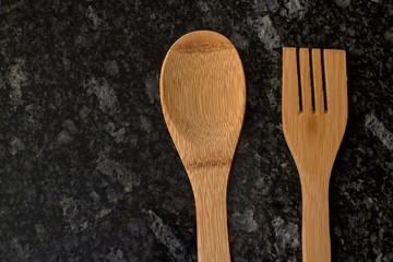 wooden spoon and fork on black marble