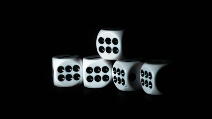 Białe kości do gry w kasynie. Kości do gry wyizolowane na czarnym tle. Kości są białe z czarnymi kropkami