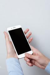 Closeup shot of a woman hold on mobile phone. Girl's hand holding a modern smartphone. Blank screen to put it on your own webpage or message.