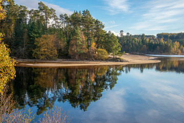 autumn trees reflected in Loch Laggan