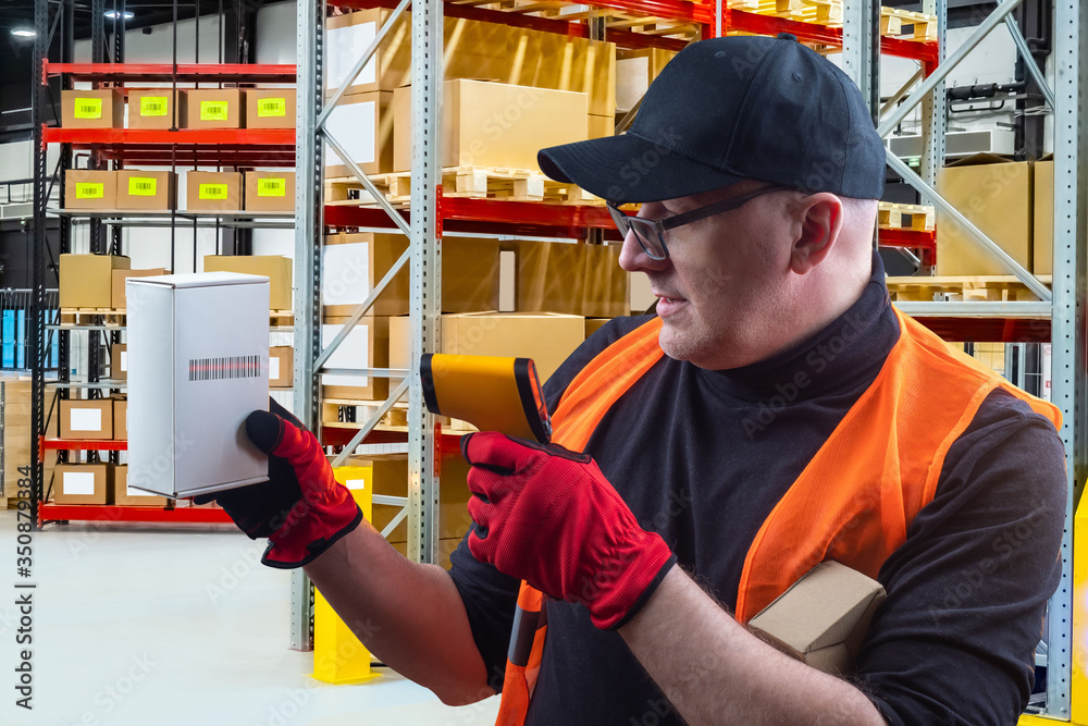 Poster inventory in the warehouse. the man checks the availability of the product using a scanner. storekee