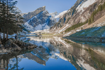 Naklejka na ściany i meble Breathtaking landscape of mountain lake with reflection of beautiful summit. Concept of Wanderlust, mountain hiking and travel. Beautiful landscape.