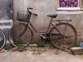 Fototapeta na wymiar brown color bicycle with basket to a wall