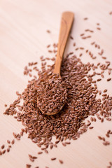 Close up Flax seeds in a wooden spoon. Healthy food background.