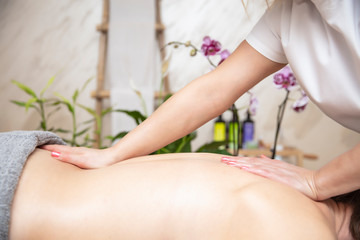 Young woman relaxing during back massage at the spa