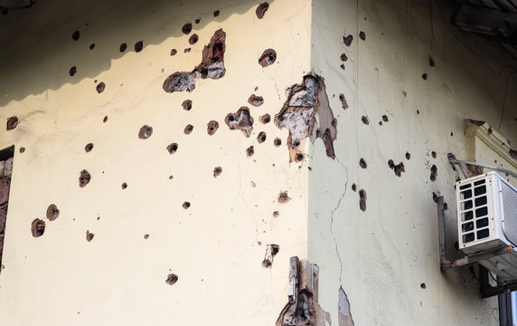 Shelled wall of a residential building. Consequences of the war in the Donbas. Housing stock of the DPR. Holes from fragments of a mine.