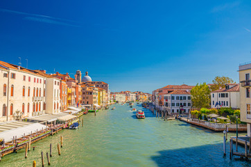 Venice cityscape with Grand Canal waterway. View from Scalzi bridge. Gondolas, boats, yachts, vaporettos docked and sailing Canal Grande. Venetian architecture buildings. Veneto Region, Italy.