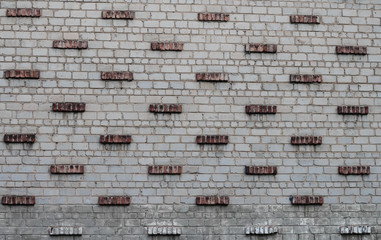 Fototapeta na wymiar Wall design made of white and red bricks. Fragment of a stone wall.