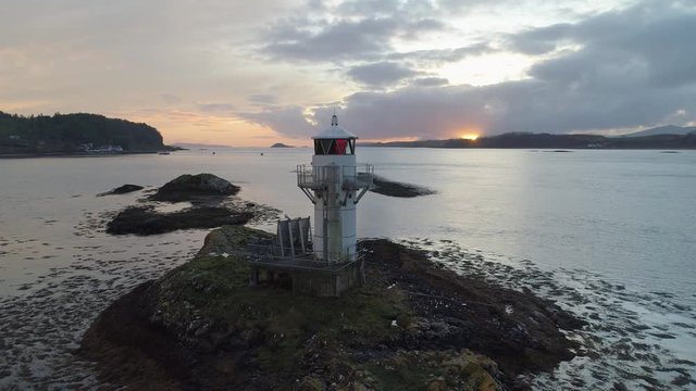 Sunset bursts through lighthouse with seagul flying off