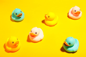 Collection of colorful rubber ducks on a yellow background