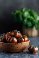 Fresh tomatoes in a plate on a dark background. Harvesting tomatoes.