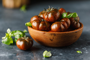 Fresh tomatoes in a plate on a dark background. Harvesting tomatoes.
