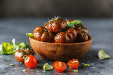 Fresh tomatoes in a plate on a dark background. Harvesting tomatoes.