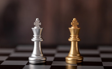 gold and silver king standing on chess board