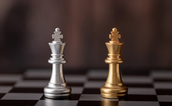 gold and silver king standing on chess board