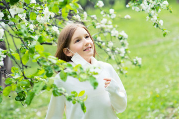 Happy teenage girl taking off her protective medicine mask against virus and allergy, breathing deeply