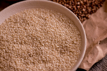 Sesame seeds in a bowl on a wooden table