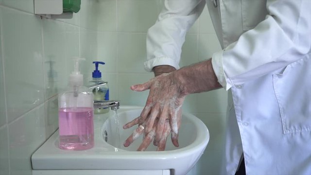 the doctor thoroughly washes his hands before after taking