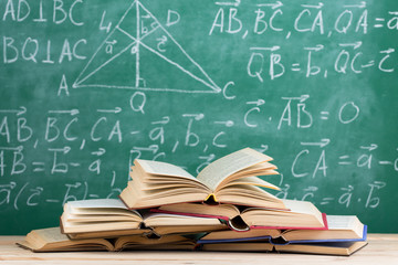 Education concept - books on the desk in the auditorium