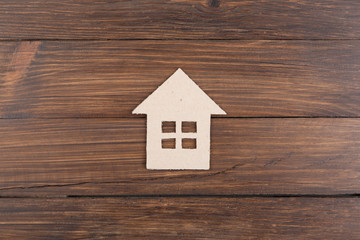 Obraz na płótnie Canvas Little cardboard house on wooden floorboards concept for real estate or renting property
