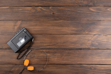 Vintage portable cassette player and headphones on a wooden background, tape recorder from 80th - 90th © Sensay