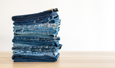 Jeans trousers stack on white background.