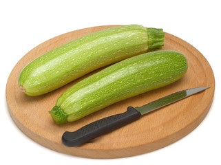 Squash, vegetables marrows, zucchini with a knife on a wooden board isolated on white background
