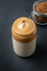 Dalgona coffee on black. Trendy korean drink with foam of instant coffee. Vertical shot.