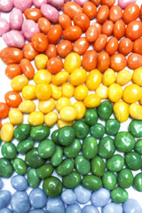 Abstract background filled with assorted bean candies making a rainbow