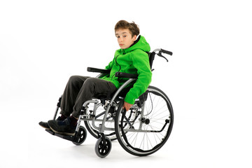 Little boy in wheelchair on white background , boy is sitting in a wheelchair on a white background. Hospital patient with disability