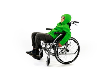 Little boy in wheelchair on white background , boy is sitting in a wheelchair on a white background. Hospital patient with disability