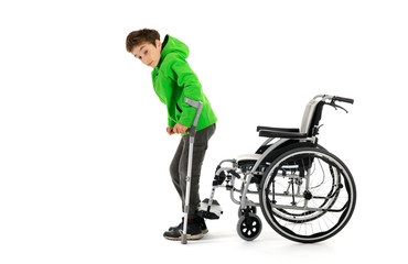 Obraz premium boy gets up from wheelchair , Wheelchair user gets up, moves away from the wheelchair , Young male person got up from a wheelchair as a result of rehabilitation