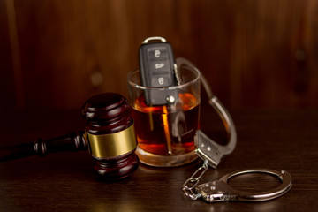 Car keys and glass of alcohol on table in pub or restaurant.