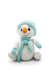 Knitted toy snowman in a hat and scarf on a white background