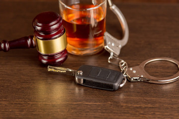Whiskey with car keys and handcuffs. Concept for drinking and driving.